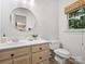 Functional powder room with round mirror, natural light, and classic fixtures at 5308 Sunningdale Dr, Charlotte, NC 28277