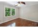 Cozy bedroom with ceiling fan and large window overlooking lush greenery at 5308 Sunningdale Dr, Charlotte, NC 28277