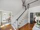 Spacious foyer featuring a staircase with elegant banister, chandelier, and hardwood floors at 5308 Sunningdale Dr, Charlotte, NC 28277
