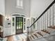 Elegant foyer features a black front door with glass sidelights and a staircase with stained treads at 5308 Sunningdale Dr, Charlotte, NC 28277