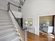 Welcoming foyer features a staircase, wainscoting, hardwood floors, and views to other rooms at 5308 Sunningdale Dr, Charlotte, NC 28277