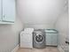 Efficient laundry room with washer, dryer, and utility sink with blue cabinetry for a functional space at 5308 Sunningdale Dr, Charlotte, NC 28277