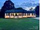 Charming ranch-style home with a well-manicured lawn at twilight at 554 Isle Of Pines Rd, Mooresville, NC 28117