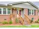 Close-up of the front porch with wooden railings, brick steps, and colorful hanging flower baskets at 622 University Dr, Rock Hill, SC 29730