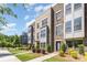 Beautiful three-story townhome featuring brick, gray accents, well-kept landscaping and blue skies at 625 Uwharrie River Rd, Charlotte, NC 28211