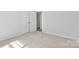 A bright bedroom featuring neutral carpeting and a white door leading to a closet at 6412 Sullins Rd, Charlotte, NC 28214