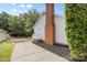 Exterior side view featuring a brick chimney, white siding, and a paved driveway at 6412 Sullins Rd, Charlotte, NC 28214