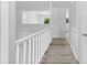 Bright hallway with wood floors, white railing, and neutral tones for a modern, airy feel at 6412 Sullins Rd, Charlotte, NC 28214