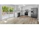 Modern kitchen with stainless steel appliances, white cabinetry, and sliding glass doors leading to the deck at 6412 Sullins Rd, Charlotte, NC 28214