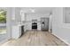 Well-lit kitchen with white cabinets, stainless steel appliances, and wood-look flooring for a fresh, clean look at 6412 Sullins Rd, Charlotte, NC 28214