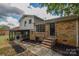 Backyard view featuring a brick house, screened porch, steps and patio area at 6921 Idlewild Rd, Charlotte, NC 28212