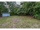 Lush backyard with outbuilding and mature trees, perfect for outdoor activities at 6921 Idlewild Rd, Charlotte, NC 28212