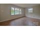 Cozy bedroom featuring fresh paint, new hardwood flooring, and lots of natural light from the windows at 6921 Idlewild Rd, Charlotte, NC 28212