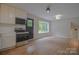 Bright kitchen featuring updated appliances, freshly painted walls, and brand new hardwood flooring at 6921 Idlewild Rd, Charlotte, NC 28212