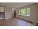 Bright living room featuring freshly painted walls, brand new hardwood flooring, and updated trim at 6921 Idlewild Rd, Charlotte, NC 28212