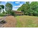The back exterior of the home features a covered porch overlooking a lush green lawn and rock drain at 6992 Sherrills Ford Rd, Sherrills Ford, NC 28673