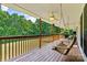 A covered back porch with wooden floors has porch swings and ceiling fans overlooking a lush backyard at 6992 Sherrills Ford Rd, Sherrills Ford, NC 28673