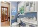 Bright bathroom with blue walls, vintage-style sink, and natural light from a window at 6992 Sherrills Ford Rd, Sherrills Ford, NC 28673