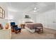 A tranquil bedroom features a ceiling fan, carpet flooring, a blue rocking chair, and a double-door closet at 6992 Sherrills Ford Rd, Sherrills Ford, NC 28673
