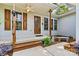 The charming covered front porch features wooden support columns, a ceiling fan, and decorative shutters at 6992 Sherrills Ford Rd, Sherrills Ford, NC 28673