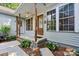 The charming covered front porch features wooden support columns, a ceiling fan, and decorative shutters at 6992 Sherrills Ford Rd, Sherrills Ford, NC 28673