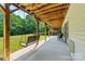 Relax on the covered patio with a porch swing, overlooking the lush green lawn and wooded area at 6992 Sherrills Ford Rd, Sherrills Ford, NC 28673