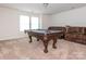 Finished basement with a pool table, carpeted floors, and a comfortable leather sofa, perfect for recreation and relaxation at 805 Old Little Rock Rd, Charlotte, NC 28214