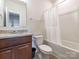 Well-maintained bathroom featuring neutral tiling, granite vanity, and a shower/tub combination with a white shower curtain at 805 Old Little Rock Rd, Charlotte, NC 28214