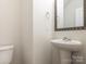 The powder room has a pedestal sink, framed mirror, and tiled floors at 805 Old Little Rock Rd, Charlotte, NC 28214