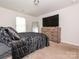Bedroom featuring a bed, television atop a dresser, mirror and carpet at 805 Old Little Rock Rd, Charlotte, NC 28214