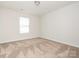 Bedroom with neutral walls and carpet, bright natural light from a window, and a clean, simple design at 805 Old Little Rock Rd, Charlotte, NC 28214