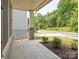 Inviting front porch area with stone pillars, landscaping, a view of a quiet street, and a glimpse of neighborhood greenery at 805 Old Little Rock Rd, Charlotte, NC 28214