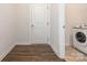 Bright laundry room features modern washer and dryer hookups, a door, and wood-look flooring at 805 Old Little Rock Rd, Charlotte, NC 28214