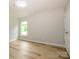 Bedroom with wood-look flooring, and window overlooking front yard at 8611 Earthenware Dr, Charlotte, NC 28269
