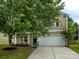 Traditional two-story home with mature landscaping, covered front porch, and two car garage at 8611 Earthenware Dr, Charlotte, NC 28269