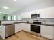 Modern kitchen with white cabinetry, stainless steel appliances, granite countertops, and wood-look flooring at 8611 Earthenware Dr, Charlotte, NC 28269