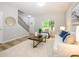 Cozy living room with wood-look flooring, a front-entry door and staircase access at 8611 Earthenware Dr, Charlotte, NC 28269