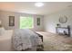 Large bedroom with wood-look flooring, neutral walls, and a large window offering plenty of natural light at 8611 Earthenware Dr, Charlotte, NC 28269