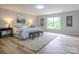Spacious bedroom featuring a plush rug, comfortable bed, and natural light from a large window at 8611 Earthenware Dr, Charlotte, NC 28269