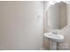 Simple powder room with pedestal sink and framed mirror at 10211 Snowbell Ct, Charlotte, NC 28215