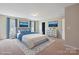 Staged primary bedroom features a queen bed, two windows, and ensuite bath at 10211 Snowbell Ct, Charlotte, NC 28215