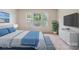 Sunlit bedroom showcasing a comfortable bed, a dresser, and three large windows, perfect for relaxation and enjoying the scenery at 10211 Snowbell Ct, Charlotte, NC 28215