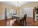 Bright dining room with hardwood floors, wainscoting, a chandelier, and natural light from large windows at 10211 Snowbell Ct, Charlotte, NC 28215
