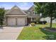 Charming two-story home featuring a manicured lawn, a two-car garage, and stone and siding accents at 10211 Snowbell Ct, Charlotte, NC 28215