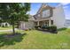 Charming two-story home featuring a manicured lawn, a three-car garage, and stone and siding accents at 10211 Snowbell Ct, Charlotte, NC 28215