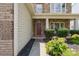 Inviting front entrance with a classic red door, complemented by lush landscaping and stone accents at 10211 Snowbell Ct, Charlotte, NC 28215