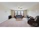 Neutral living room featuring a ceiling fan, carpeted floors, and natural light from the triple windows at 10211 Snowbell Ct, Charlotte, NC 28215