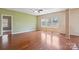 Spacious living room with hardwood floors, large windows, and a ceiling fan at 10211 Snowbell Ct, Charlotte, NC 28215