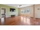 Spacious living room with hardwood floors, large windows, and a ceiling fan at 10211 Snowbell Ct, Charlotte, NC 28215