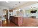Open-concept living room features hardwood floors, a spacious island, and easy access to the staircase at 10211 Snowbell Ct, Charlotte, NC 28215